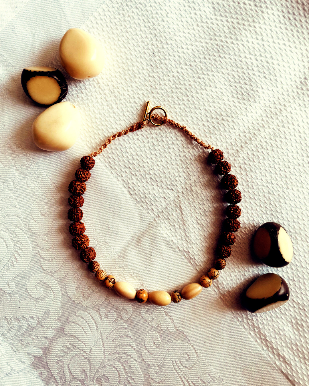 lesfiletsdelaparqueuse-valeriebienetreholistique-collierterresacrée Collier tissé en rudraksha, ivoire végétal et graines naturelles, bijou sacré artisanal